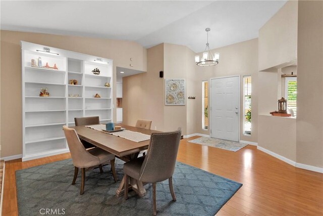 13950 High Falls Trl, Apple Valley, CA 92307 - dining space featuring a chandelier, baseboards, wood finished floors, and lofted ceiling