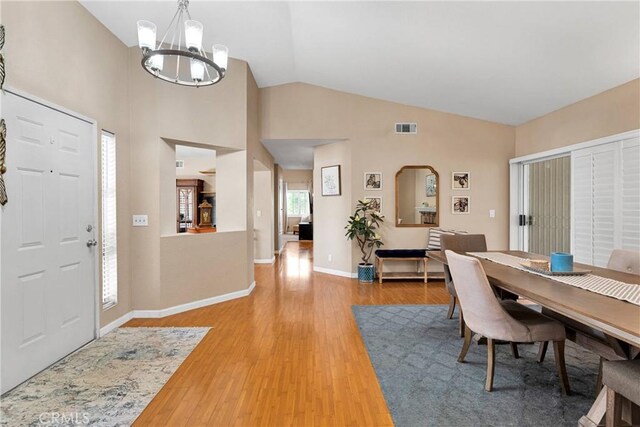13950 High Falls Trl, Apple Valley, CA 92307 - dining room featuring a chandelier, wood finished floors, baseboards, and high vaulted ceiling