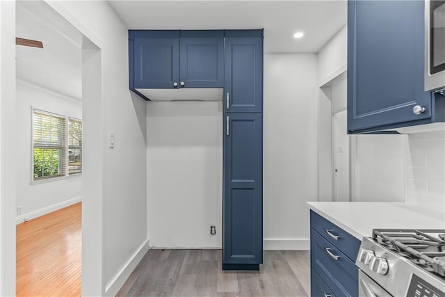 2125 256th St, Lomita, CA 90717 - kitchen with blue cabinetry, light countertops, light wood finished floors, recessed lighting, and stainless steel microwave