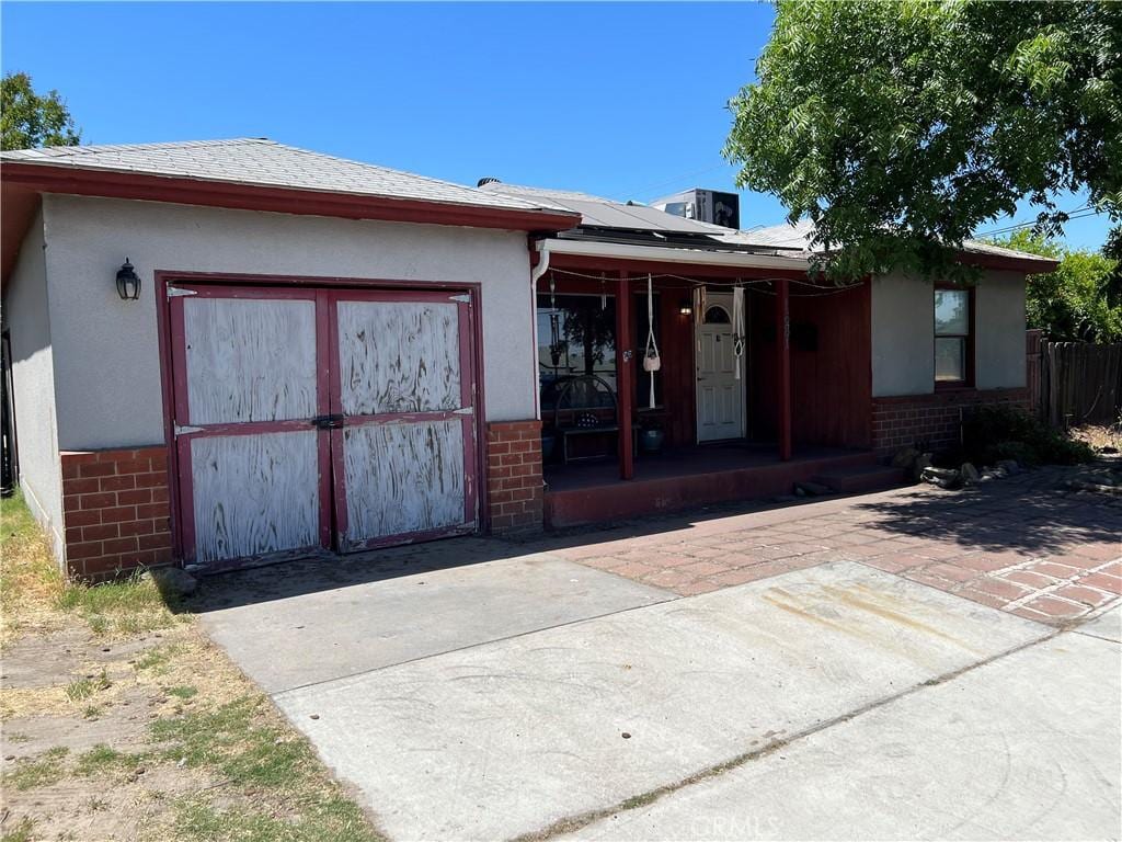 1681 Winton Way, Atwater, CA 95301 - back of house with brick siding, roof mounted solar panels, a porch, and stucco siding