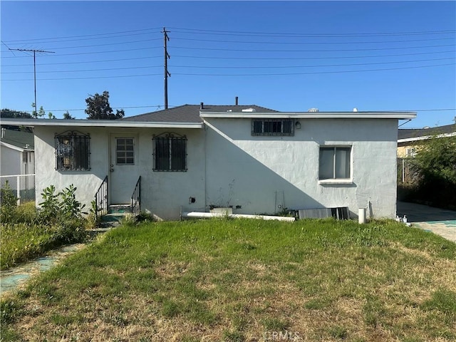 725 W K St, Colton, CA 92324 - rear view of property with stucco siding and a lawn