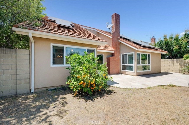 8072 Sundance Ln, La Palma, CA 90623 - back of house featuring roof mounted solar panels, a patio, stucco siding, and a fenced backyard