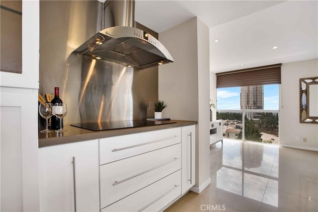 2160 Century Park E Unit 1512, Los Angeles, CA 90067 - detailed view of island exhaust hood, tasteful backsplash, black electric cooktop, recessed lighting, and baseboards