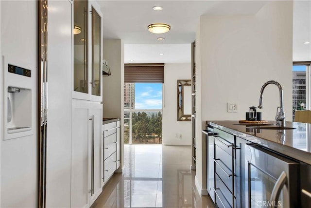 2160 Century Park E Unit 1512, Los Angeles, CA 90067 - kitchen featuring beverage cooler, a sink, dark countertops, glass insert cabinets, and recessed lighting