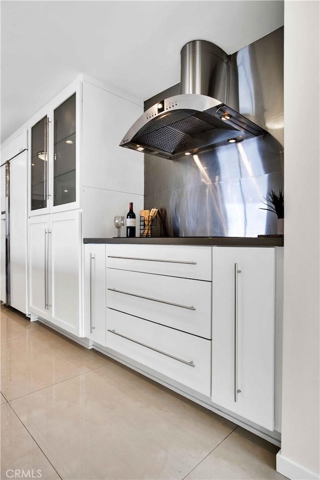 2160 Century Park E Unit 1512, Los Angeles, CA 90067 - kitchen featuring light tile patterned floors, wall chimney exhaust hood, white cabinets, and glass insert cabinets