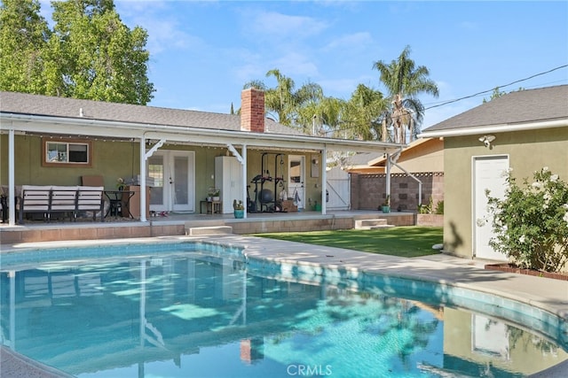23920 Vanowen St, West Hills, CA 91307 - back of property with a chimney, a gate, stucco siding, and an outdoor pool
