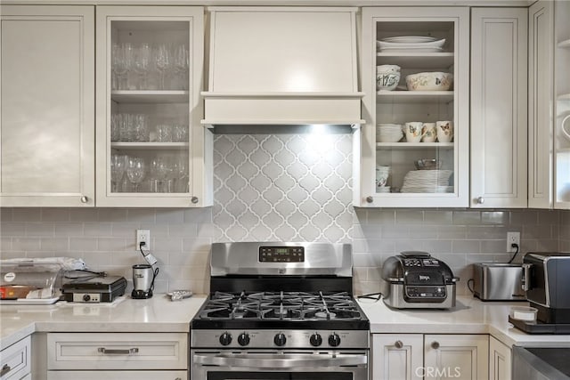 23920 Vanowen St, West Hills, CA 91307 - kitchen featuring gas range, light countertops, glass insert cabinets, and decorative backsplash