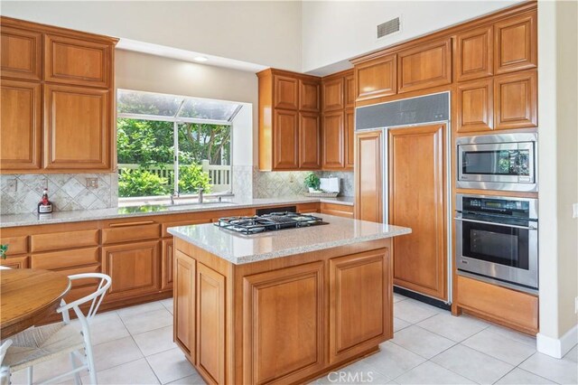 28291 La Plumosa, Laguna Niguel, CA 92667 - kitchen featuring built in appliances, a sink, light tile patterned flooring, and a kitchen island