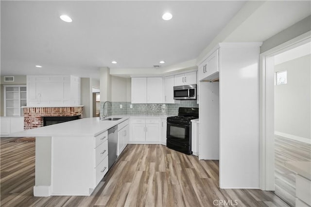 31070 Larchwood St, Menifee, CA 92584 - kitchen with appliances with stainless steel finishes, light wood-style flooring, light countertops, tasteful backsplash, and a peninsula