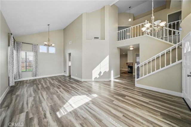 31070 Larchwood St, Menifee, CA 92584 - unfurnished living room featuring a chandelier, high vaulted ceiling, stairway, and wood finished floors