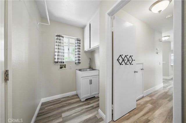 31070 Larchwood St, Menifee, CA 92584 - laundry area featuring cabinet space, light wood-style flooring, and hookup for a washing machine