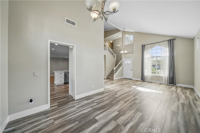 31070 Larchwood St, Menifee, CA 92584 - unfurnished living room with a chandelier, high vaulted ceiling, stairs, and wood finished floors