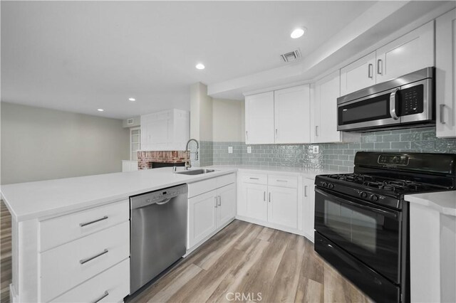 31070 Larchwood St, Menifee, CA 92584 - kitchen with stainless steel appliances, a peninsula, white cabinetry, light wood finished floors, and decorative backsplash
