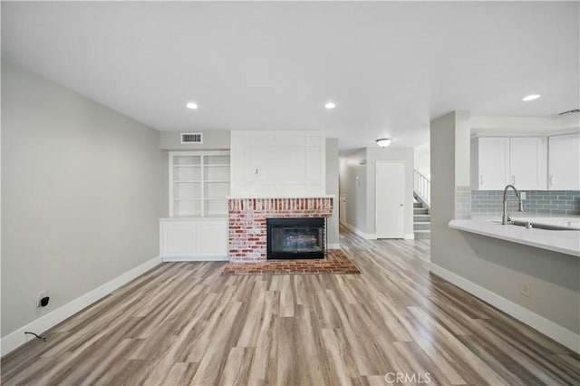 31070 Larchwood St, Menifee, CA 92584 - unfurnished living room with a fireplace, light wood-style floors, recessed lighting, and stairs