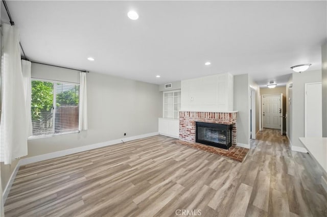 31070 Larchwood St, Menifee, CA 92584 - unfurnished living room with light wood finished floors, a brick fireplace, and recessed lighting