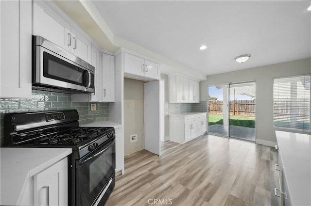31070 Larchwood St, Menifee, CA 92584 - kitchen featuring gas stove, stainless steel microwave, light countertops, decorative backsplash, and white cabinetry