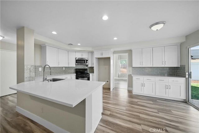 31070 Larchwood St, Menifee, CA 92584 - kitchen with stainless steel microwave, gas stove, plenty of natural light, light countertops, and recessed lighting