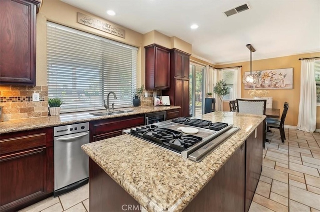 23328 Stone Rdg, Murrieta, CA 92562 - kitchen with a sink, stainless steel gas cooktop, a center island, backsplash, and healthy amount of natural light