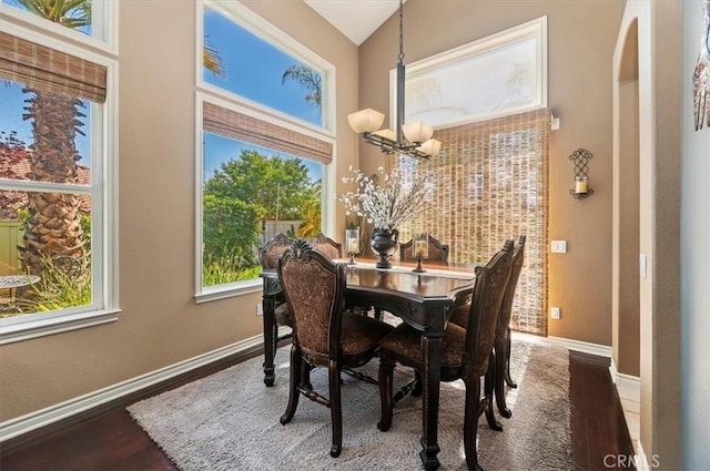 23328 Stone Rdg, Murrieta, CA 92562 - dining area featuring wood finished floors, baseboards, arched walkways, and a chandelier