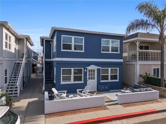 502 36th St, Newport Beach, CA 92663 - back of property with stairway, an outdoor living space with a fire pit, stucco siding, and a patio