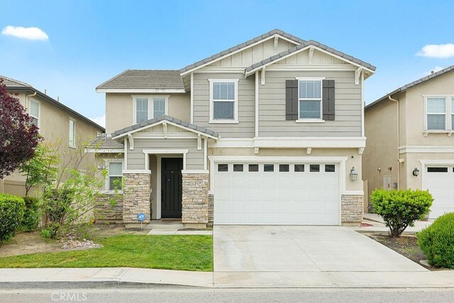 706 Leather Oak Ln, Pomona, CA 91766 - craftsman-style house featuring stone siding, an attached garage, concrete driveway, and board and batten siding