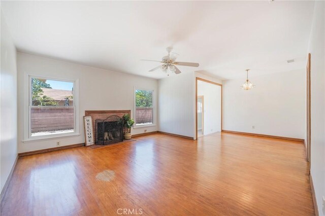 404 N Pear Knl, Anaheim, CA 92805 - unfurnished living room featuring wood finished floors, a fireplace with flush hearth, baseboards, and a ceiling fan