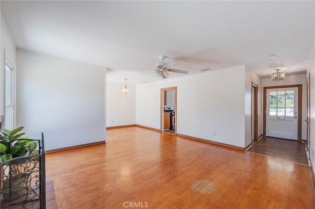 404 N Pear Knl, Anaheim, CA 92805 - unfurnished living room with a chandelier, light wood-style flooring, baseboards, and a ceiling fan