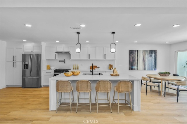 22526 Lake Forest Ln, Lake Forest, CA 92630 - kitchen with stainless steel refrigerator with ice dispenser, recessed lighting, gas stove, light countertops, and light wood-style floors