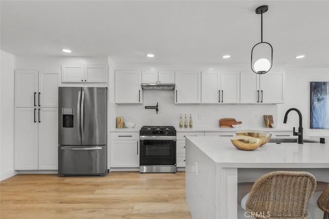 22526 Lake Forest Ln, Lake Forest, CA 92630 - kitchen featuring stainless steel refrigerator with ice dispenser, range with gas stovetop, white cabinets, hanging light fixtures, and recessed lighting