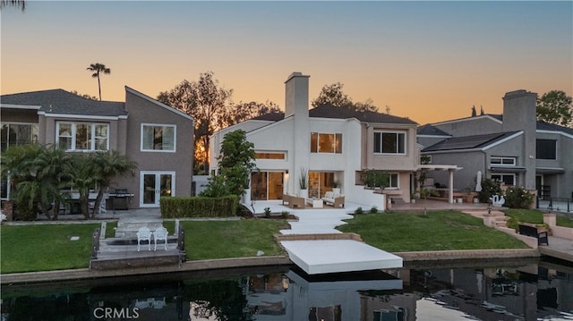 22526 Lake Forest Ln, Lake Forest, CA 92630 - back of property at dusk with a patio area, a chimney, stucco siding, and outdoor lounge area
