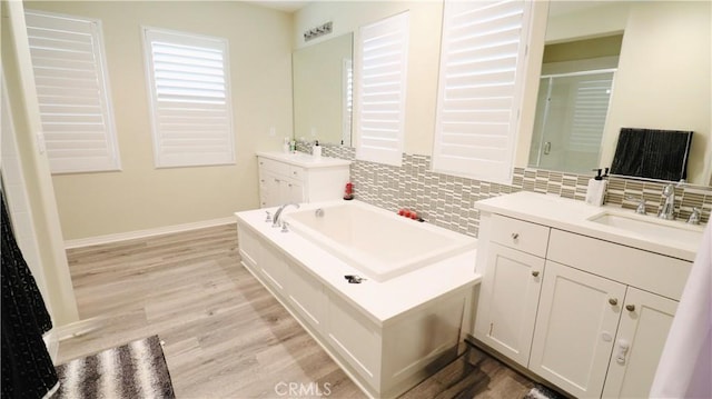 27506 Aster Way, Saugus, CA 91350 - bathroom with decorative backsplash, wood finished floors, a stall shower, a garden tub, and baseboards