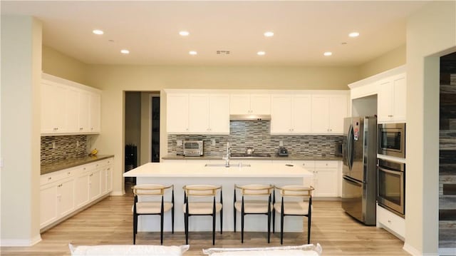 27506 Aster Way, Saugus, CA 91350 - kitchen featuring stainless steel appliances, a sink, backsplash, a kitchen island with sink, and white cabinets