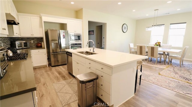 27506 Aster Way, Saugus, CA 91350 - kitchen with appliances with stainless steel finishes, a sink, extractor fan, light wood finished floors, and backsplash
