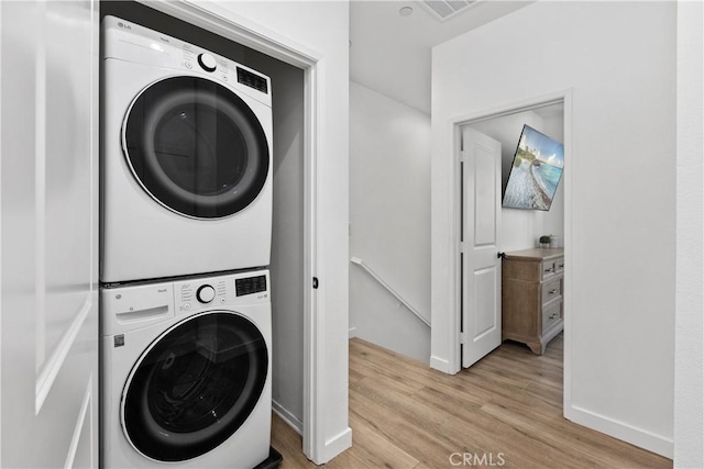 1733 San Eugenio, San Diego, CA 92154 - laundry room featuring estacked washer and dryer, light wood-style floors, and baseboards