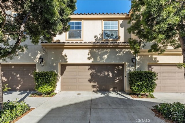 1733 San Eugenio, San Diego, CA 92154 - view of front facade featuring stucco siding, driveway, an attached garage, and a tile roof