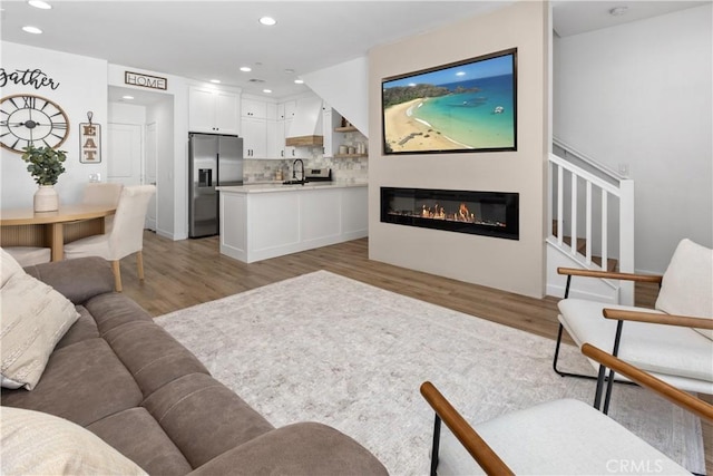 1733 San Eugenio, San Diego, CA 92154 - living area featuring light wood-style flooring, recessed lighting, stairs, and a glass covered fireplace