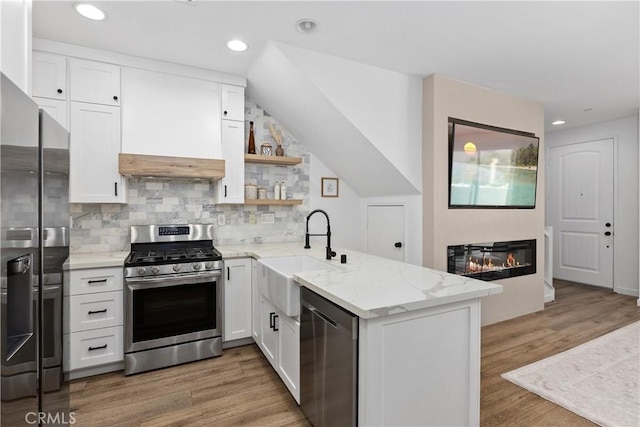 1733 San Eugenio, San Diego, CA 92154 - kitchen featuring appliances with stainless steel finishes, a sink, a peninsula, white cabinetry, and decorative backsplash