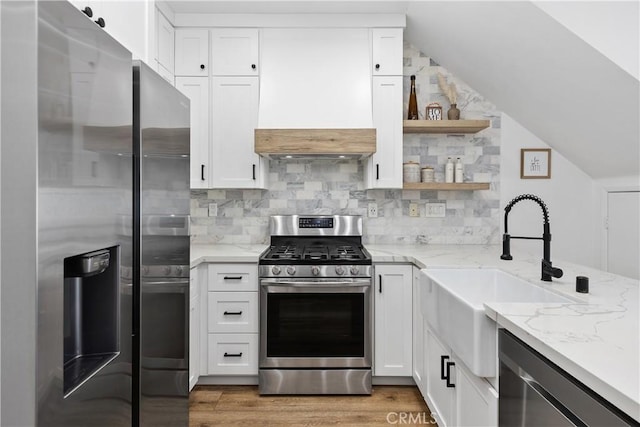 1733 San Eugenio, San Diego, CA 92154 - kitchen featuring appliances with stainless steel finishes, light stone countertops, white cabinetry, backsplash, and vaulted ceiling