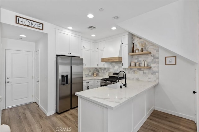 1733 San Eugenio, San Diego, CA 92154 - kitchen featuring appliances with stainless steel finishes, baseboards, custom exhaust hood, a peninsula, and light wood-type flooring