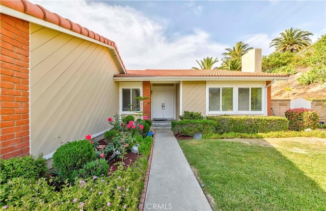 2501 Tiffany Pl, Fullerton, CA 92833 - doorway to property featuring a tile roof, a lawn, and brick siding