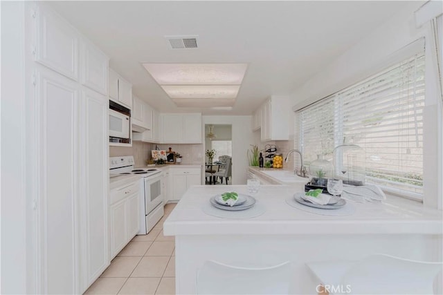 2501 Tiffany Pl, Fullerton, CA 92833 - kitchen featuring white appliances, a sink, light tile patterned floors, a peninsula, and white cabinets