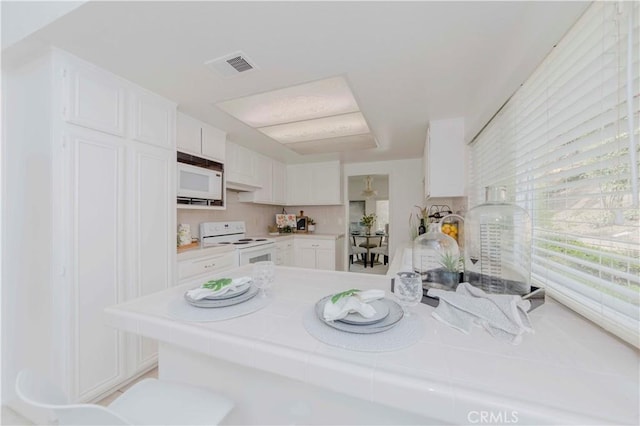 2501 Tiffany Pl, Fullerton, CA 92833 - kitchen with white appliances, white cabinets, tile counters, and a peninsula