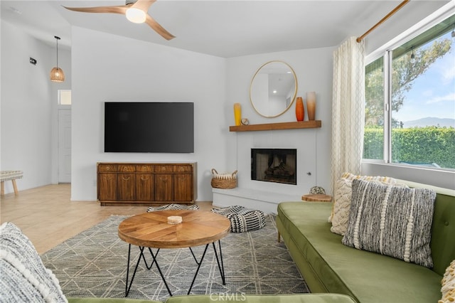 49239 Barrymore St, Indio, CA 92201 - living area featuring ceiling fan, a fireplace with raised hearth, and tile patterned floors