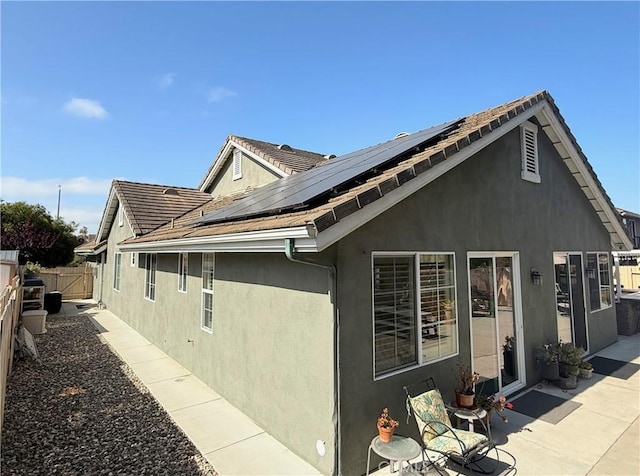 757 Onstott Rd, Lompoc, CA 93436 - view of side of home featuring stucco siding, a fenced backyard, roof mounted solar panels, a patio, and a tile roof