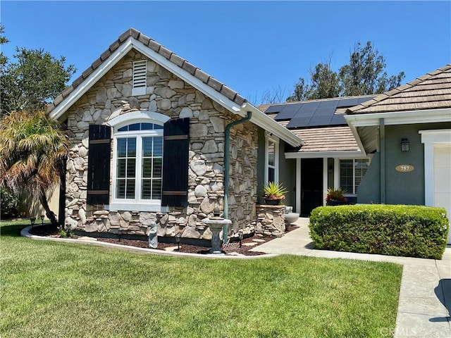 757 Onstott Rd, Lompoc, CA 93436 - view of front facade with stone siding, roof mounted solar panels, a front yard, and a tiled roof