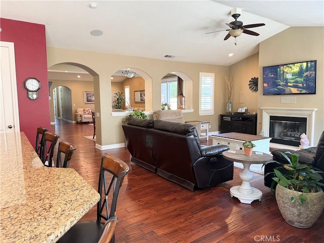 757 Onstott Rd, Lompoc, CA 93436 - living room featuring dark wood-style flooring, ceiling fan, arched walkways, vaulted ceiling, and a glass covered fireplace