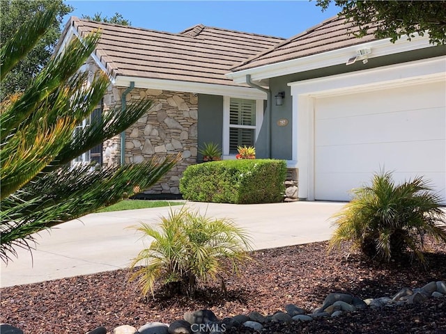 757 Onstott Rd, Lompoc, CA 93436 - property entrance with a tile roof, concrete driveway, a garage, and stucco siding