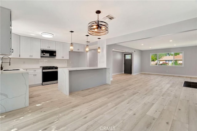 7741 Shoup Ave, West Hills, CA 91304 - kitchen with stainless steel microwave, range, a sink, open floor plan, and light countertops