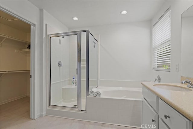 84260 Tramonto Way, Indio, CA 92203 - bathroom with a shower stall, wood finished floors, a bath, vanity, and recessed lighting