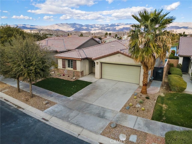 84260 Tramonto Way, Indio, CA 92203 - view of front of home with stucco siding, a mountain view, a garage, a tiled roof, and driveway
